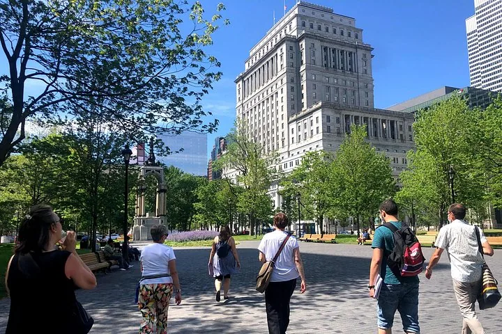 People walking through a city square towards a large historic building