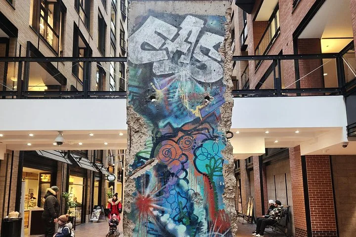Segmento del Muro di Berlino con graffiti in uno spazio interno